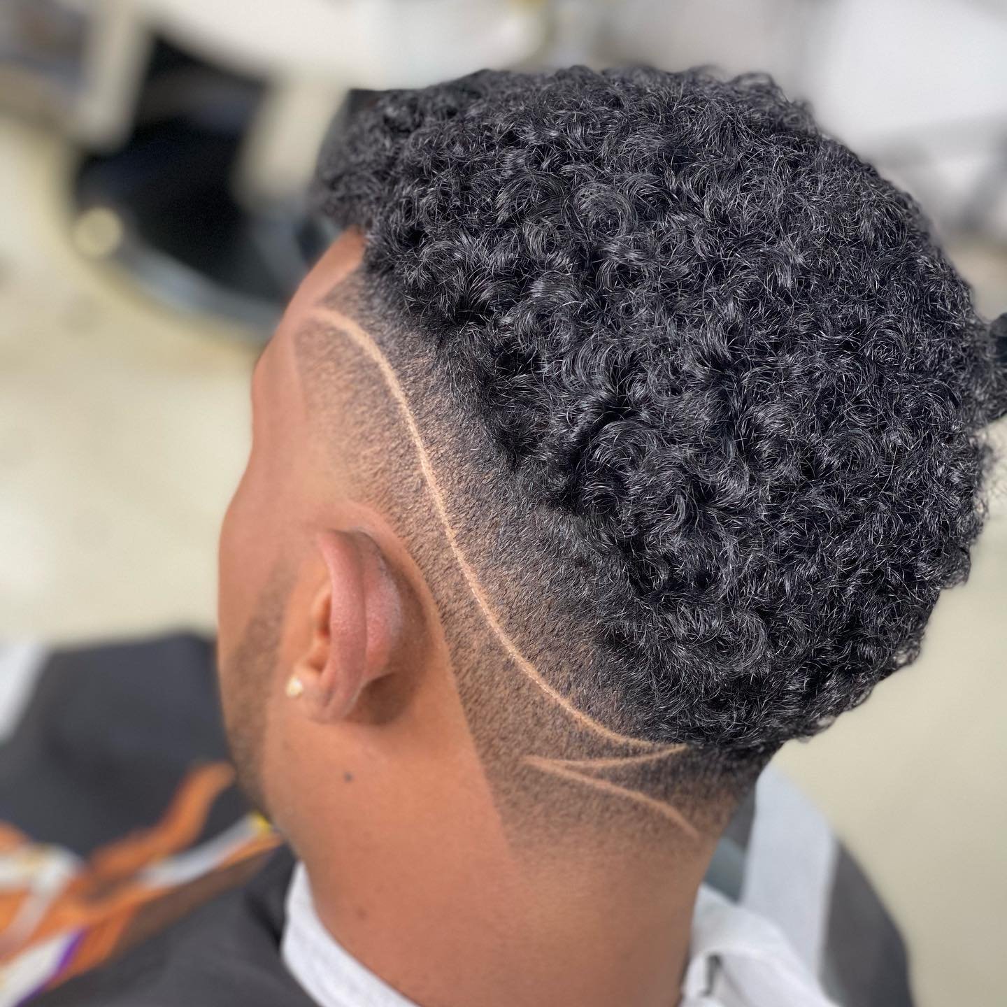 Curly top fade with a freestyle hair design