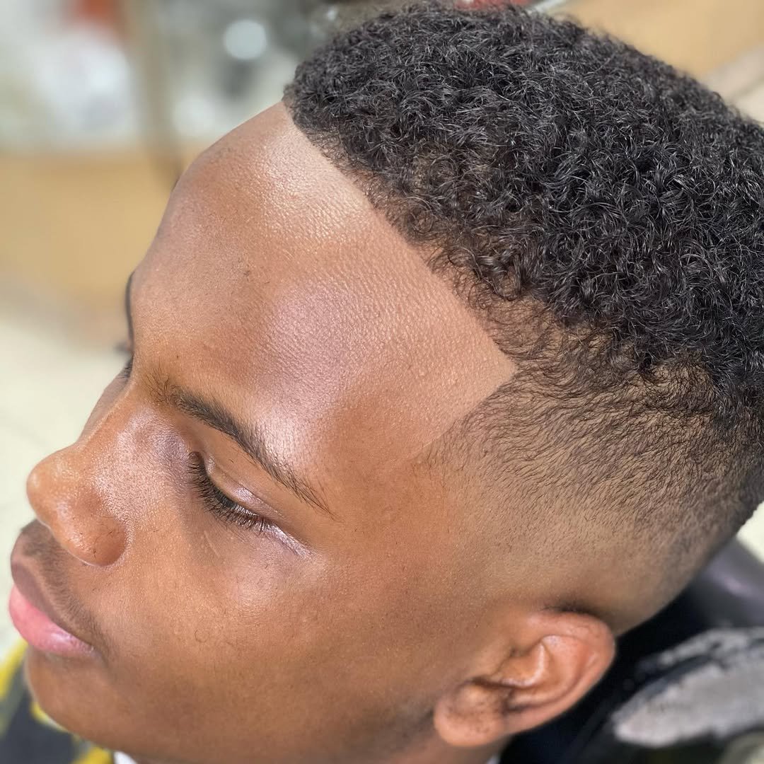 Curly top with a taper fade and crisp lineup