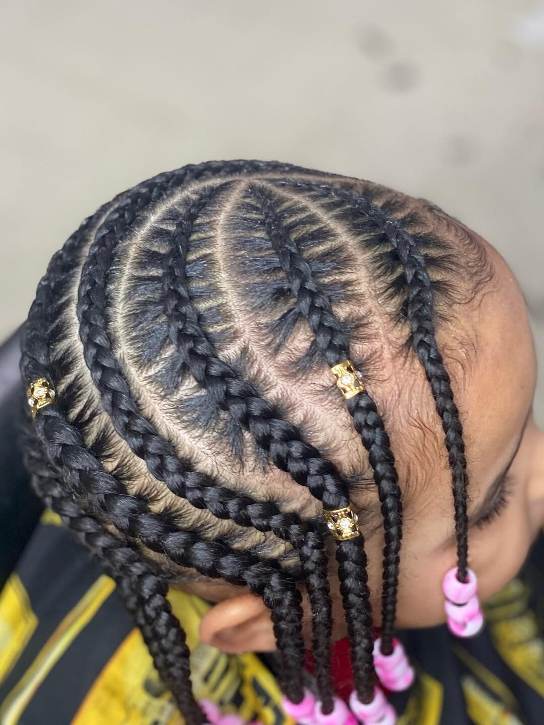 Kids cornrow braids with gold cuffs and pink beads, braided at Major Cuts